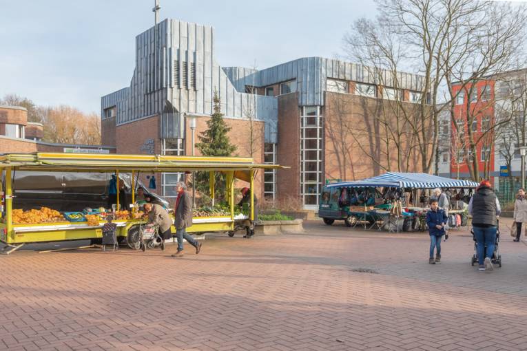 Menschen laufen über den Wochenmarkt in Groß-Buchholz.